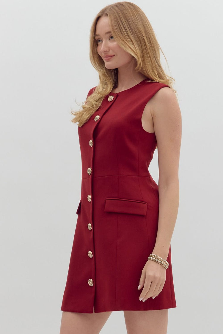 Solid sleeveless mini dress featuring gold accent button front closure